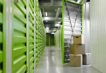 surface-image-green-self-storage-facility-with-opened-unit-door-cardboard-boxes-copy-space_236854-24686